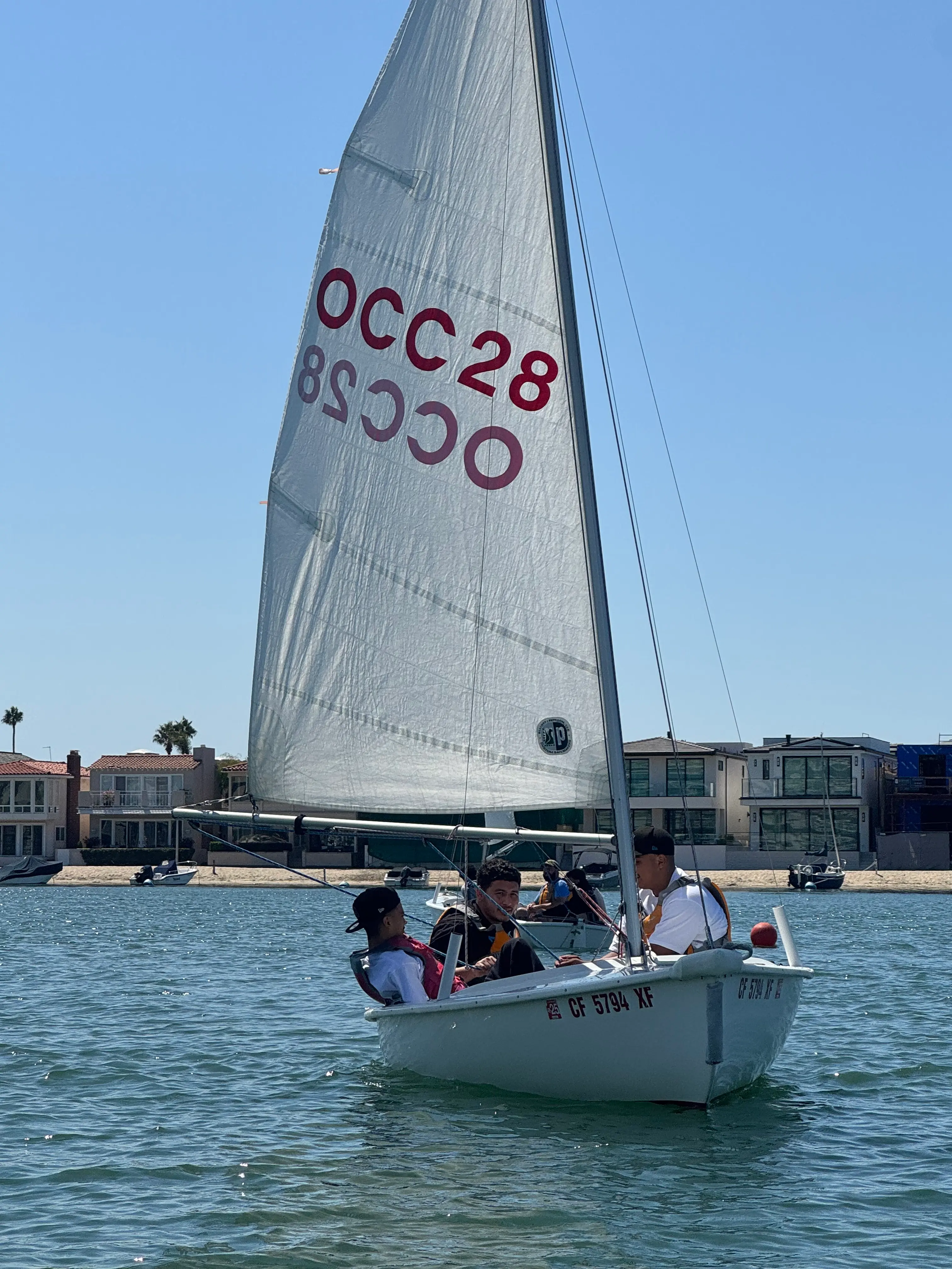 Program participants sailing a small boat near Newport Beach